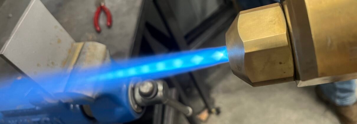 Title: HVOF Thermal Spray - High Velocity Oxygen Fuel Coating Process HVOF thermal spray system with blue flame, applying a high-velocity oxygen fuel coating for aerospace and industrial components.